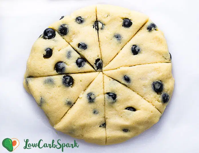 Cut the blueberry scones into triangles and arrange them onto a baking tray. Bake them to get the perfect moist keto blueberry scones. 