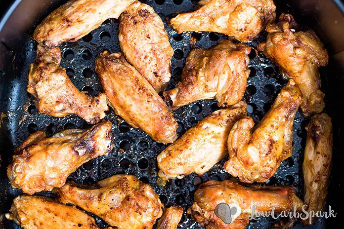 These Air Fryer Chicken Wings are super crispy, and the meat is juicy. Cooking Chicken Wings in an Air Fryer instead of deep frying makes them a healthy choice. This extremely popular recipe is ready 30 minutes and super easy to make! Toss them in a delicious low carb Buffalo sauce, and your meal is ready. #airfryer #chickenrecipes #airfryerrecipes #chickenwings