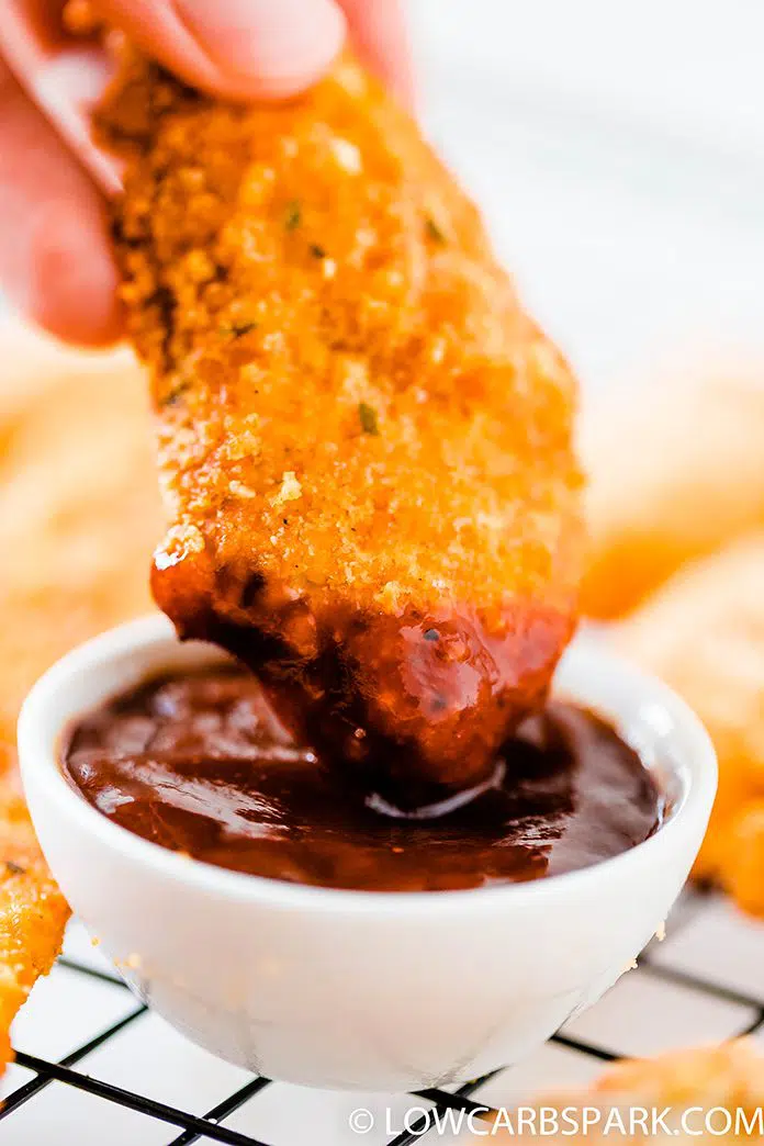 Easy Oven Baked Crispy Chicken Tenders dipped in barbeque sauce