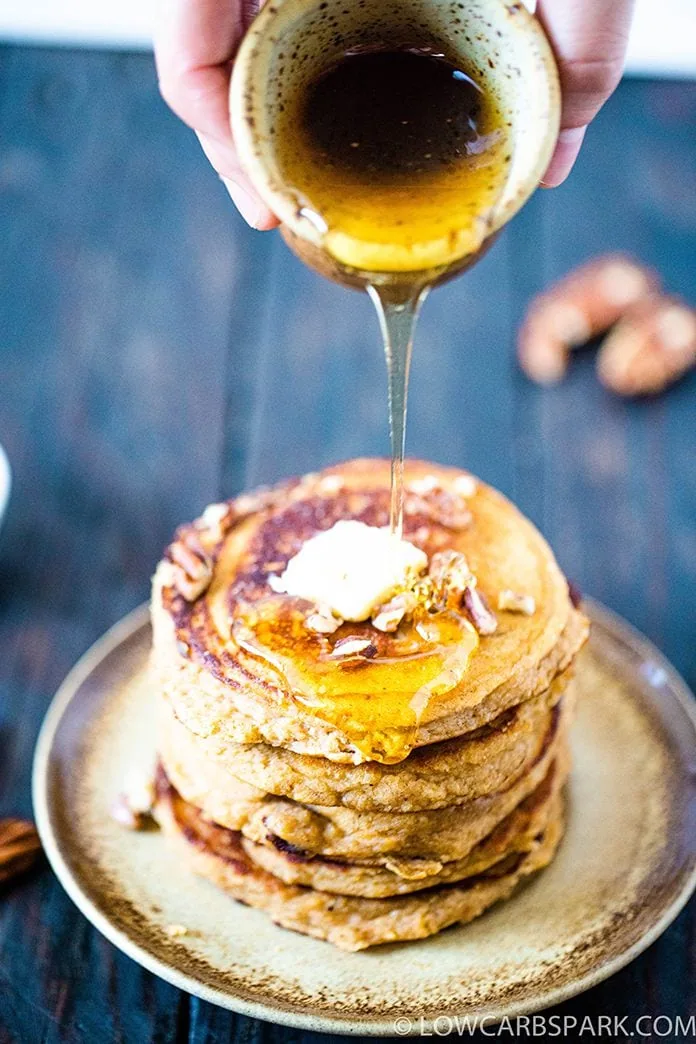 Keto Pumpkin Pancakes 4 pour sugar free sauce over a tall stack of pancakes