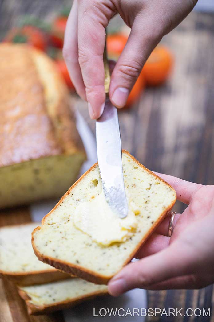 A slice of keto bread topped with butter. Delicious and easy to make low carb bread with almond flour and coconut flour for the best texture and no eggy taste bread. 