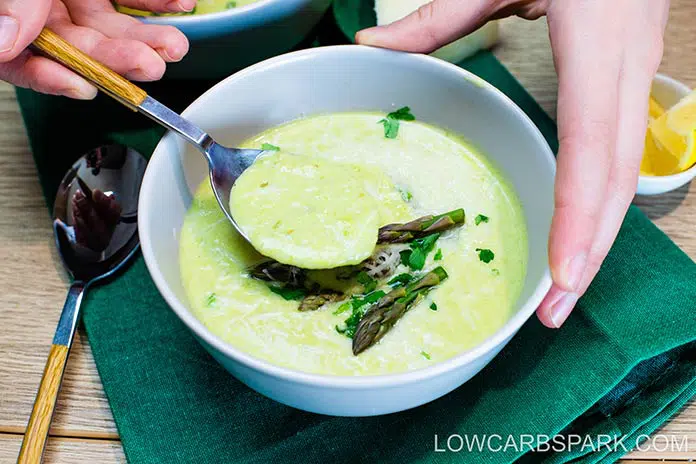 asparagus creamy soup in a bowl served with parmesan