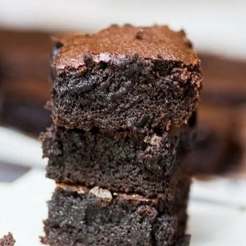The Best Fudgy Keto Brownies 2 Close-up of gluten-free almond flour brownies in a three-piece stack, highlighting their gooey chocolate center