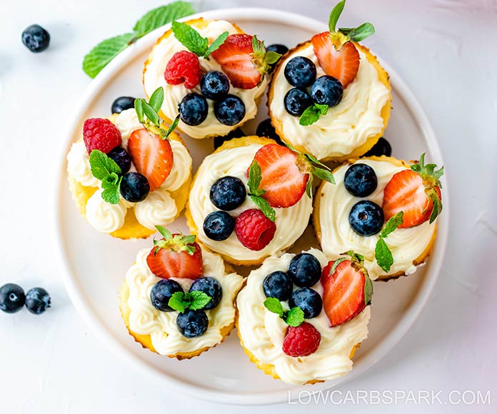 keto mini cheesecake bites served with berries on a white plate