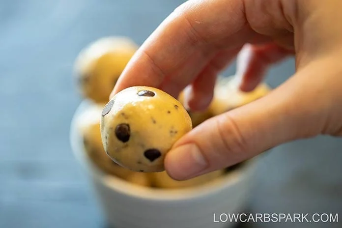 No-Bake Peanut Butter Protein Balls 2 Hand holding one chocolate chip peanut butter protein ball with a soft, chewy texture, perfect for low carb snacking.