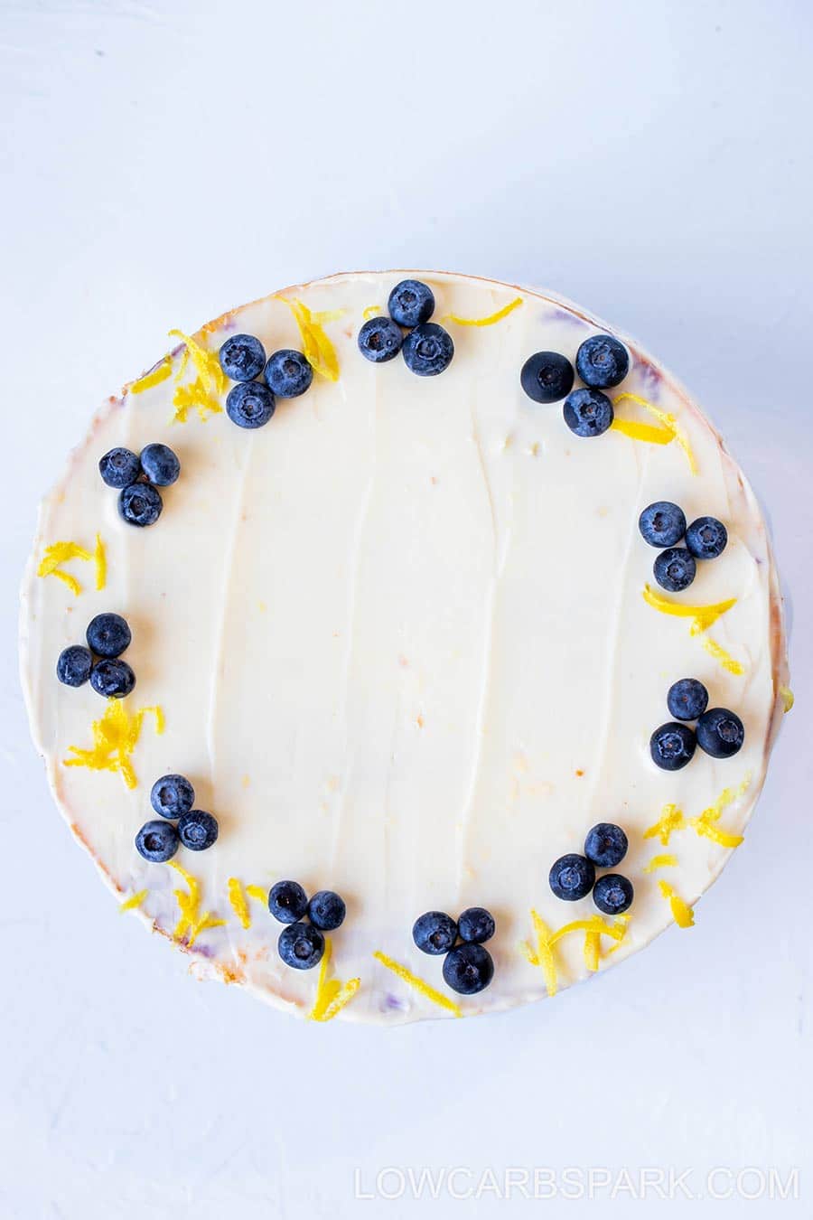 decorate keto lemon blueberry cake with lemon cream cheese frosting