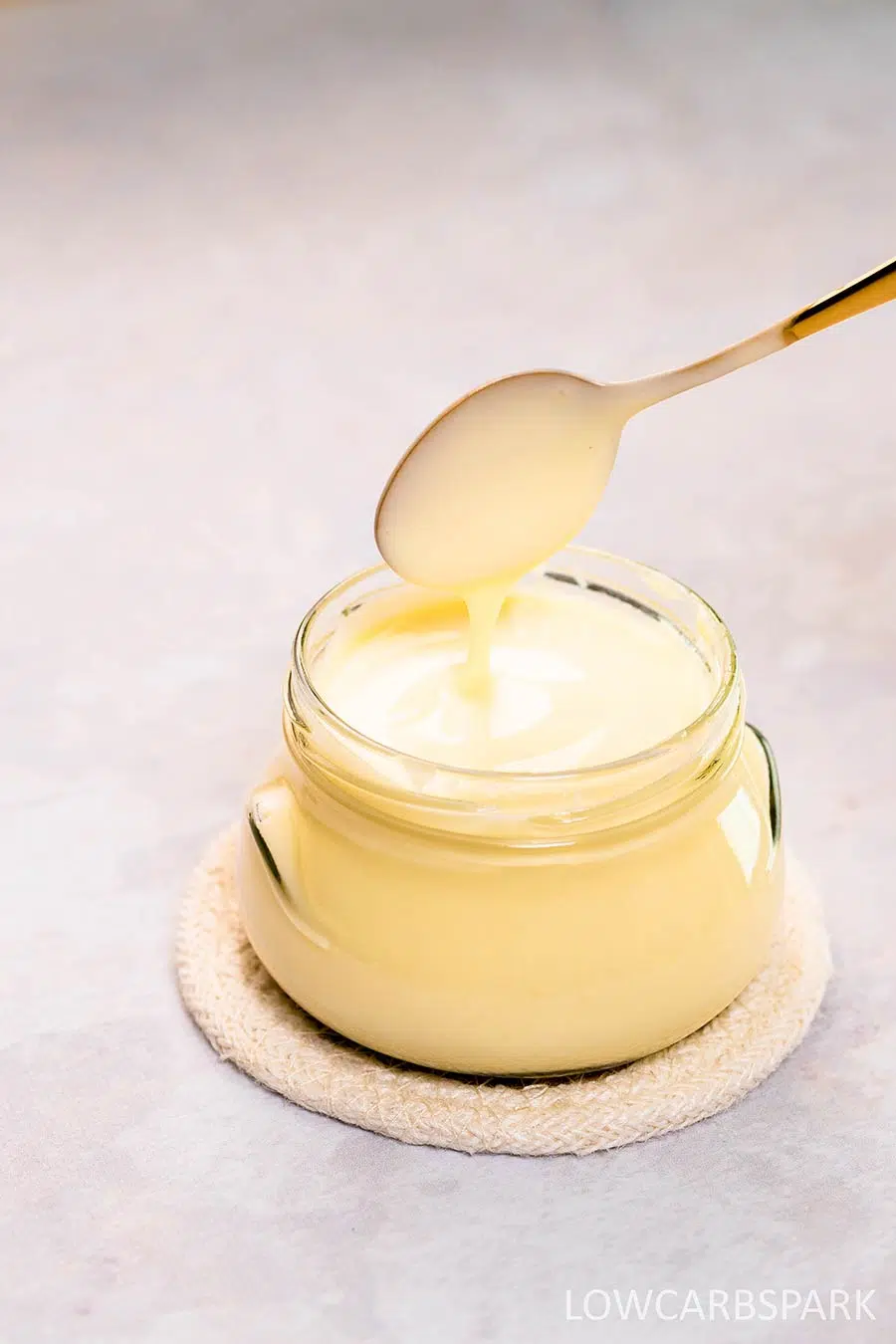 Keto Condensed Milk 8 Drizzling keto condensed milk from a spoon back into the jar