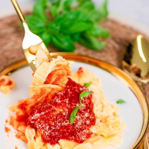 keto pasta recipe in a fork with red sauce on top