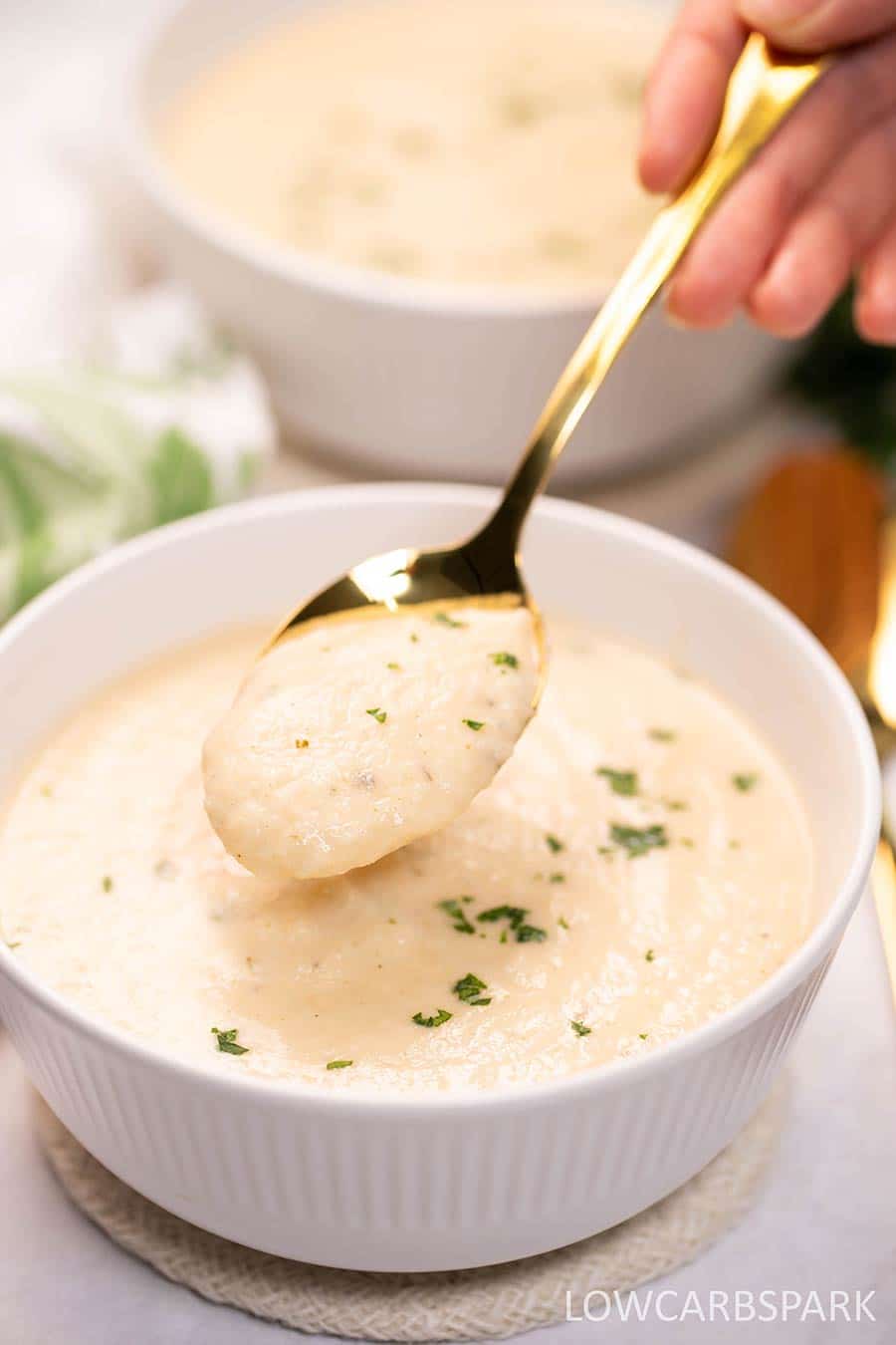 Keto Cauliflower Soup in a bowl with a spoon