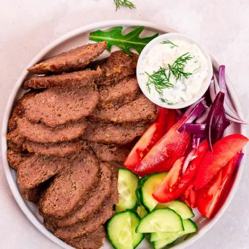 Gyro Meat Recipe 9 Juicy sliced gyro meat served in a low carb pita with lettuce, tomato, and tzatziki.