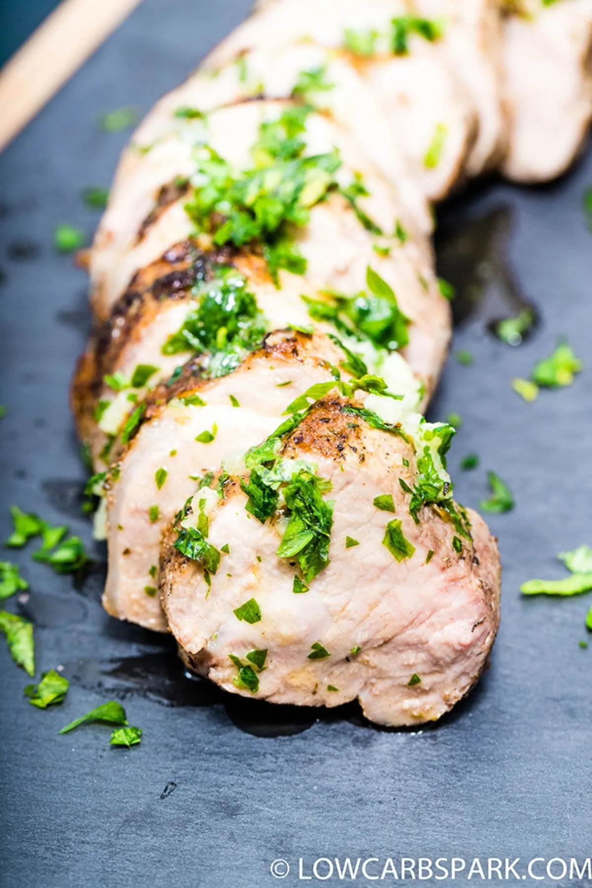 Garlic Butter Pork Tenderloin 2 a close up of garlic butter pork tenderloin sliced with parsley on top