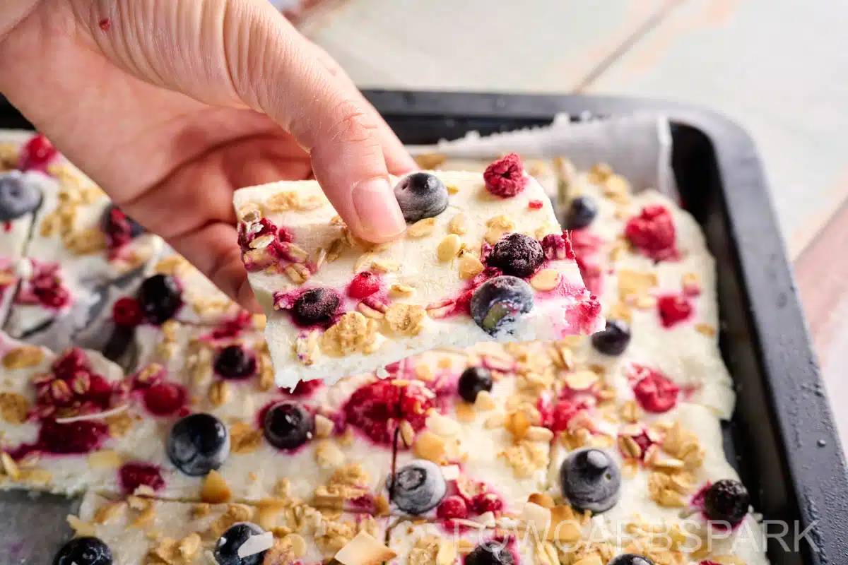Close-up of frozen yogurt bark piece showing the textures of berries and granola.