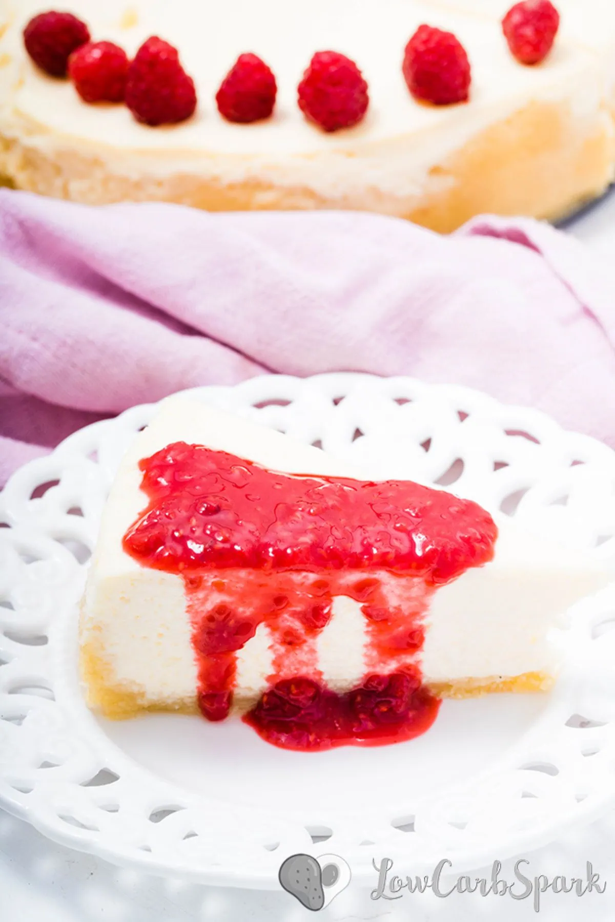 The Best Keto Cheesecake 17 keto cheesecake slice with raspberry jam on a plate
