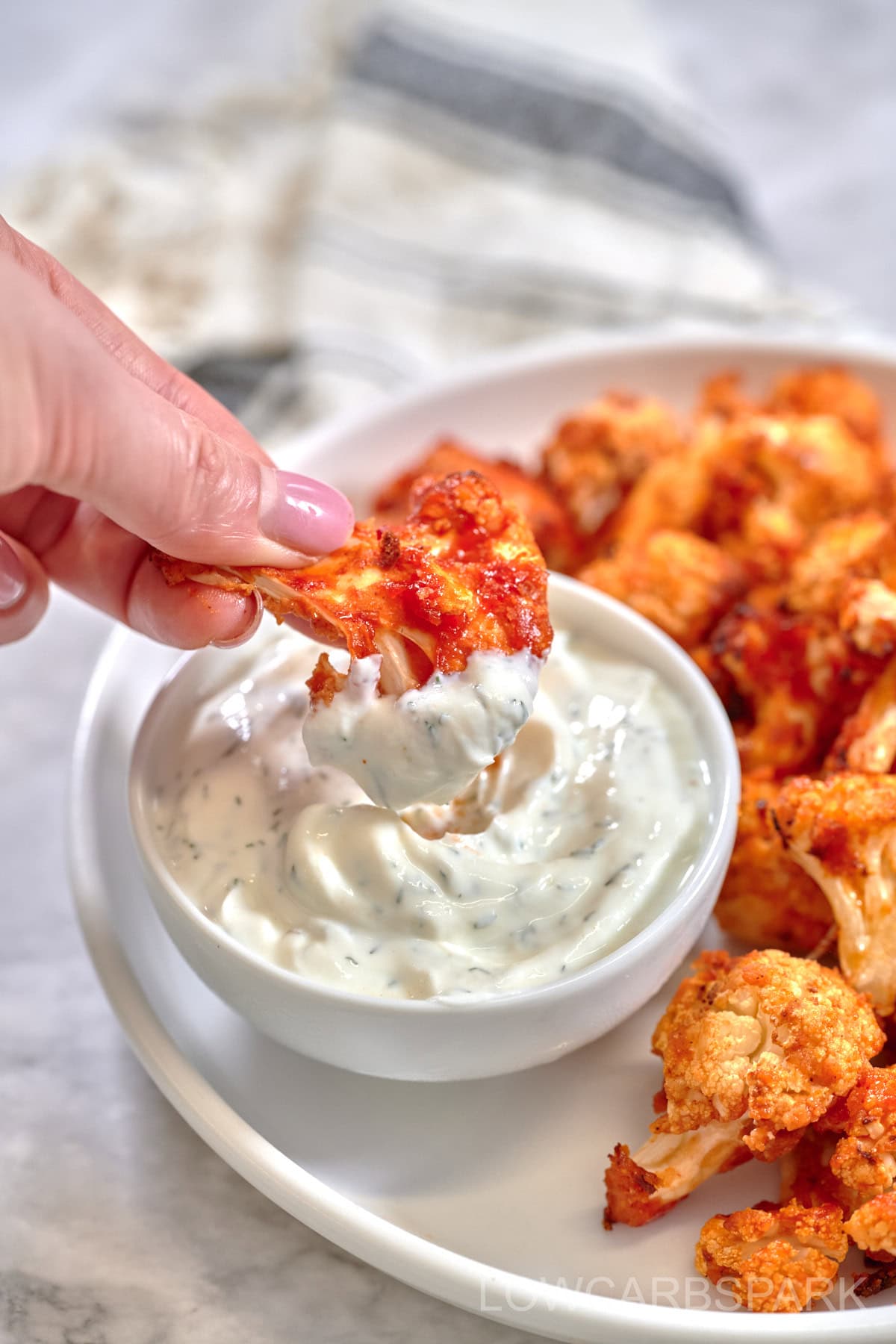 Crispy Air Fryer Buffalo Cauliflower bites dipped in creamy ranch sauce