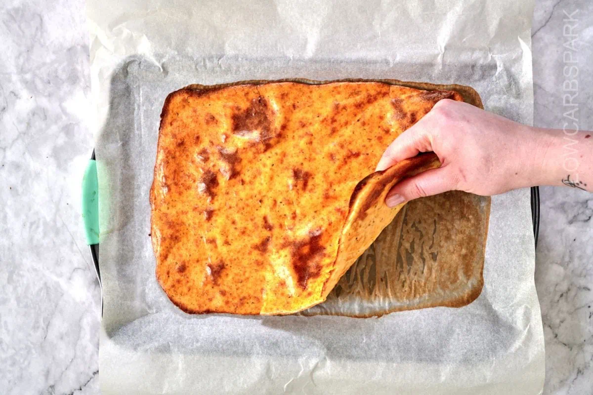 Viral Cottage Cheese Wrap 9 A hand lifting a freshly baked cottage cheese wrap to showcase its flexible texture.