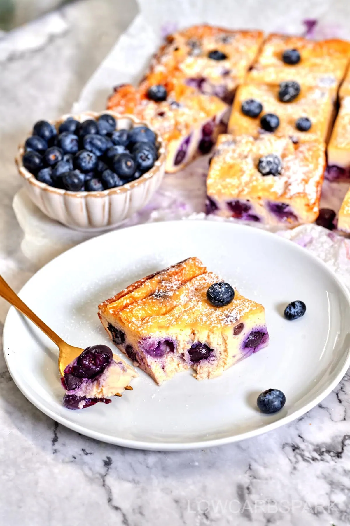 Greek Yogurt Bake 2 Low-carb Greek yogurt bake served with a dusting of powdered sweetener and fresh blueberries.