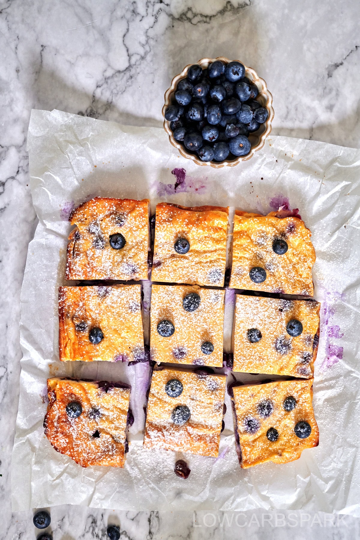 Freshly baked yogurt square showing golden edges and soft berry-filled center.
