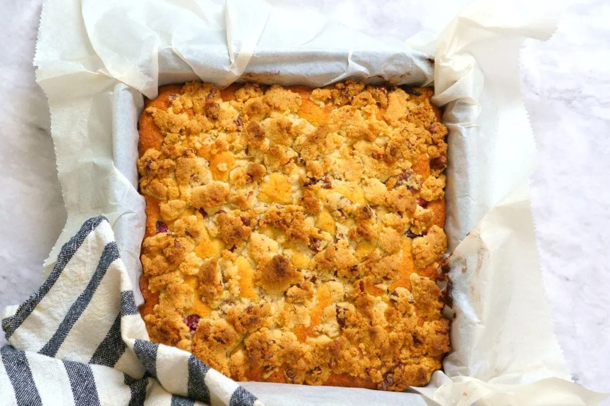 Cranberry Crumb Cake 7 Freshly baked cranberry crumb cake cooling in parchment-lined pan.