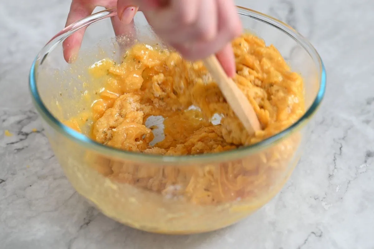 Keto Cheddar Bread 4 Mixing keto cheddar bread batter in a glass bowl with a wooden spoon