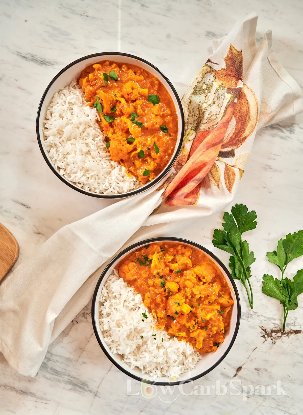 Cauliflower Curry 9 Two bowls of cauliflower curry and rice on a marble table.