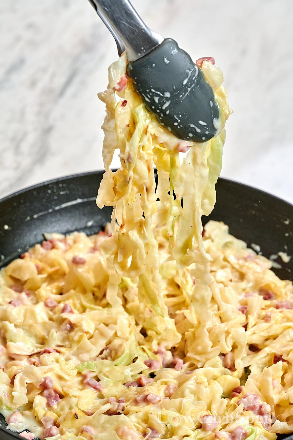 Cabbage Carbonara 11 Close-up of cabbage noodles tossed in rich carbonara sauce with bacon pieces.