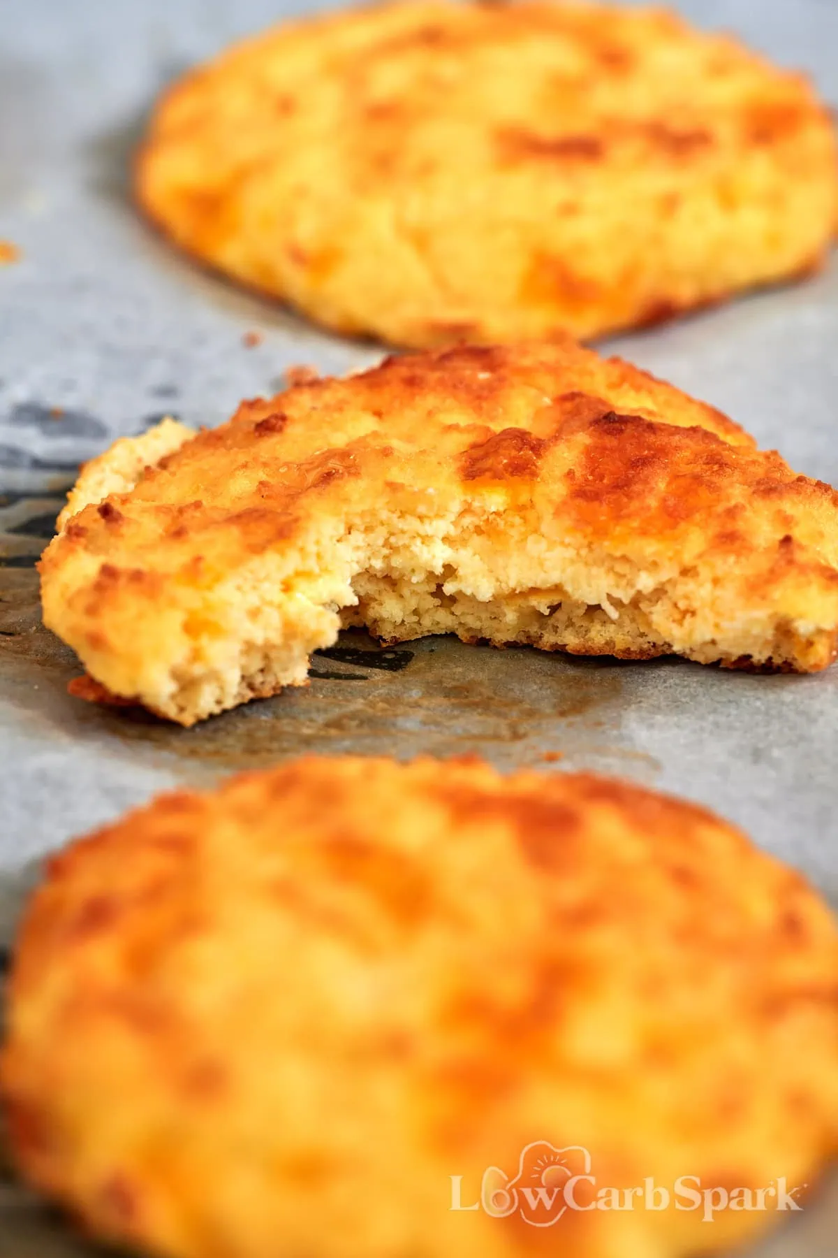 Low Carb Cottage Cheese Biscuits 9 Fluffy cottage cheese biscuit with a bite taken out, showing a soft, tender, coconut flour crumb.