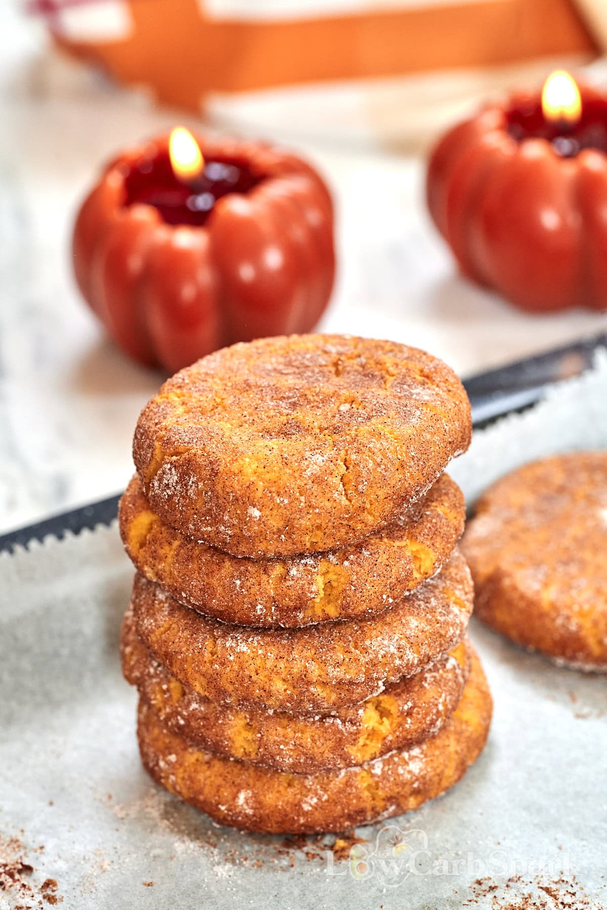 Keto Pumpkin Snickerdoodle Cookies 11 Stack of cinnamon-coated pumpkin cookies beside fall decorations