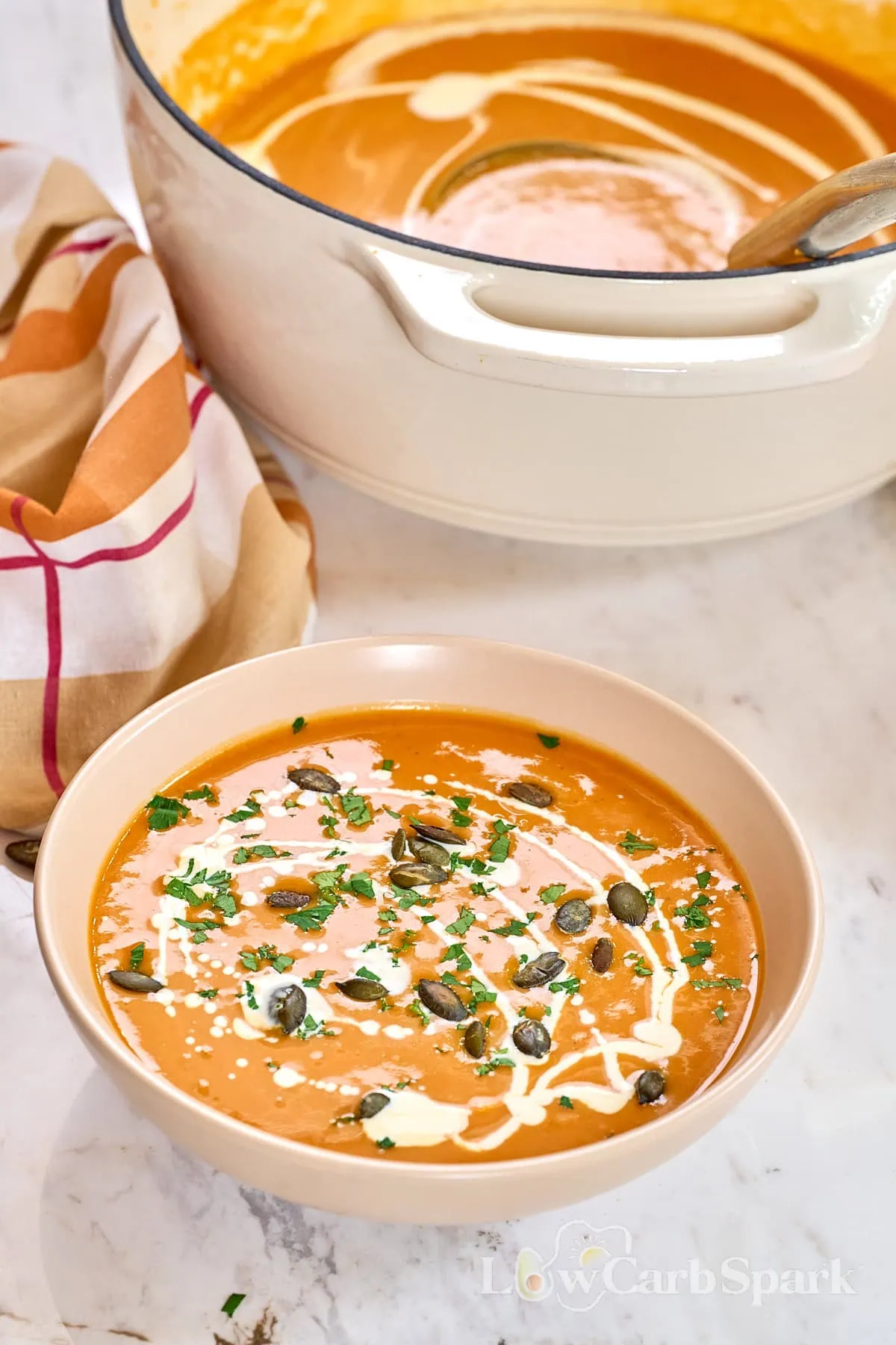 Creamy Roasted Butternut Squash Soup 4 Bowl of butternut squash soup beside a Dutch oven filled with soup