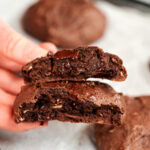 High-protein chocolate breakfast cookie broken in half showing a soft, fudgy center with melted dark chocolate