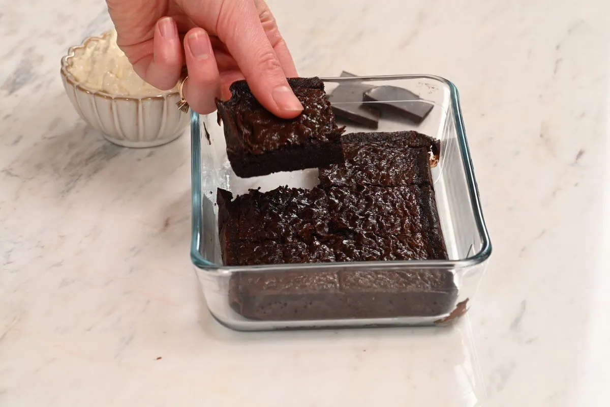 Single-Serve High-Protein Chocolate Brownie 7 Fudgy single-serve high-protein chocolate brownie being lifted from the baking dish