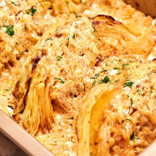 Creamy Garlic Butter Melting Cabbage 10 Creamy baked cabbage wedges in a casserole dish topped with garlic parmesan sauce and fresh herbs.