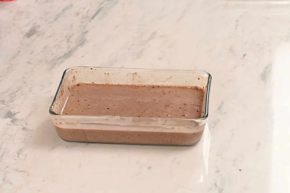 High Protein Tiramisu Chia Pudding 5 Chocolate chia pudding mixture stirred until smooth in a rectangular glass container.