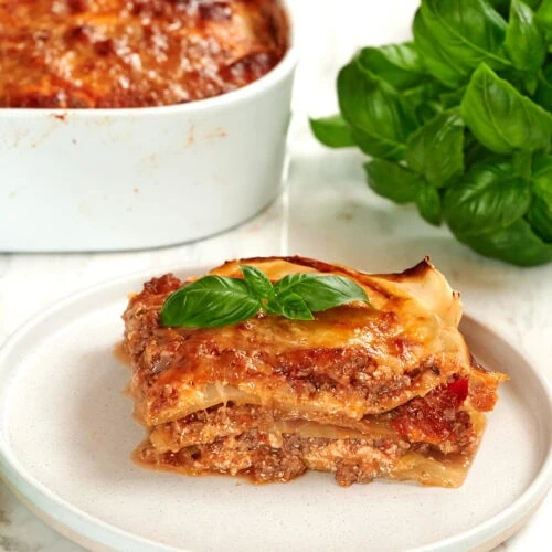 High-Protein Cabbage Lasagna 14 Slice of cabbage lasagna served on a plate with fresh basil.