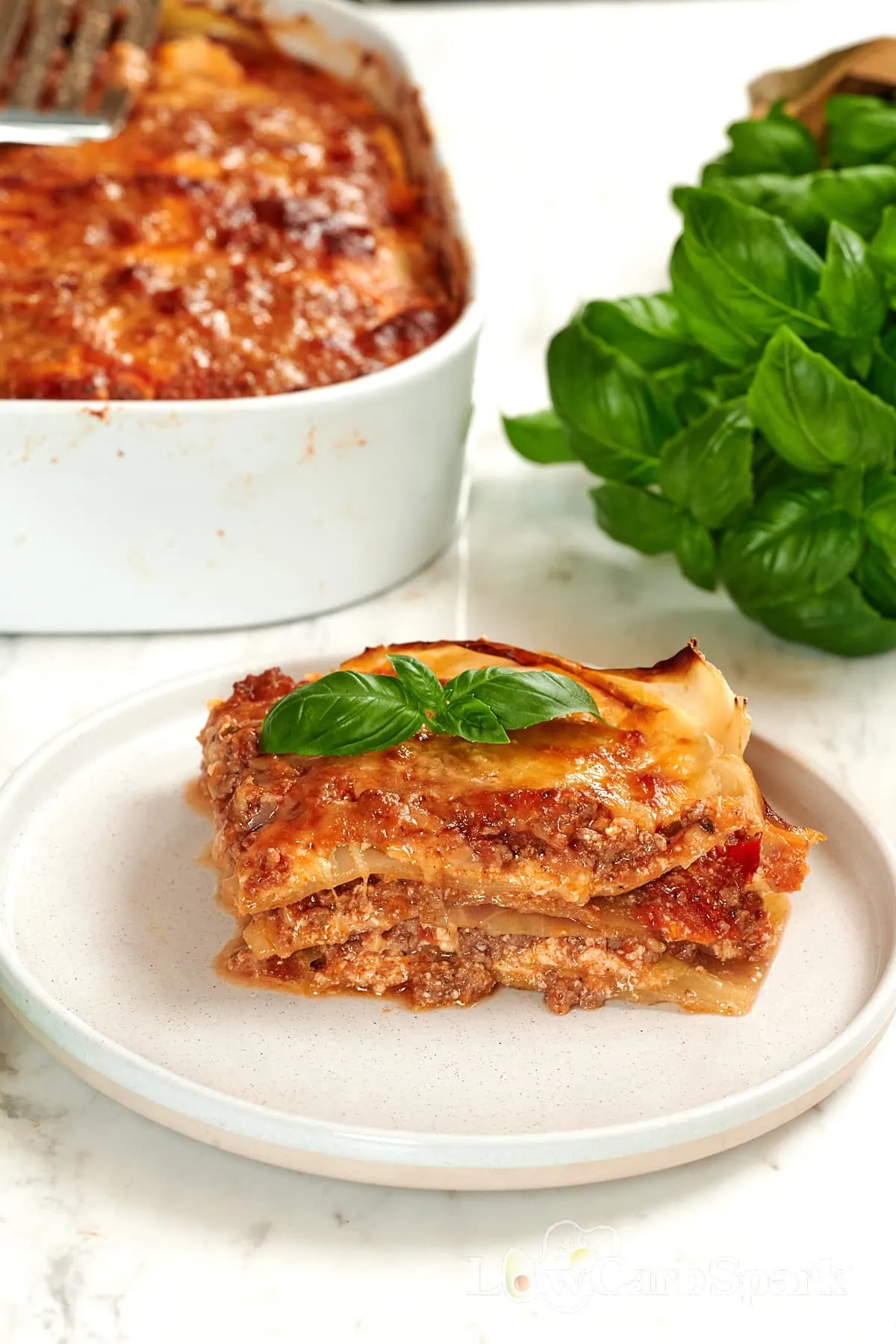 High-Protein Cabbage Lasagna 1 Slice of cabbage lasagna served on a plate with fresh basil.