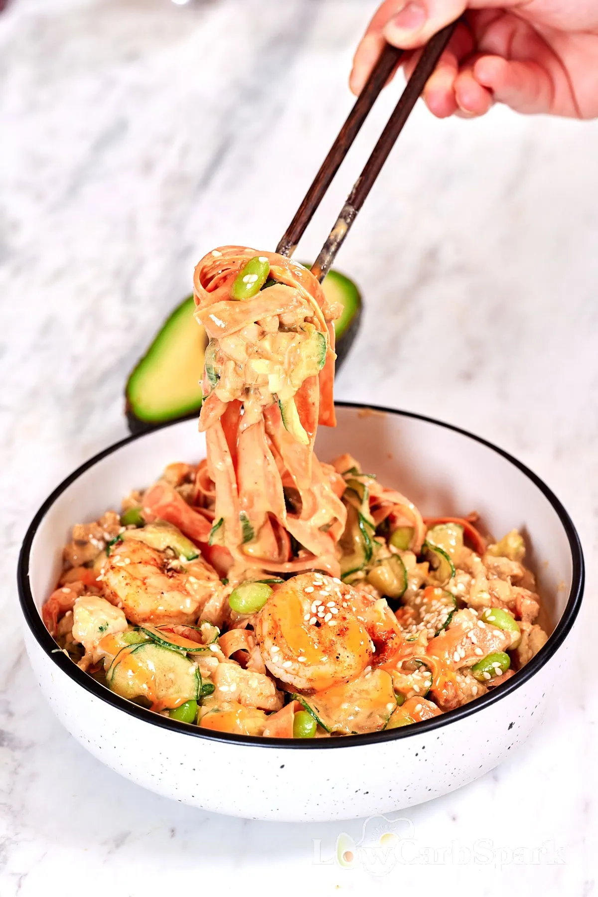 High-Protein Sushi Roll Salad (Spicy Shrimp Jar Salad) 1 Chopsticks lifting sushi roll salad with shrimp, cucumber ribbons, edamame, and creamy spicy sauce