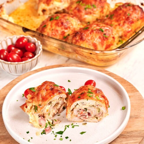 Famous Chicken Breast Rolls 2 Sliced chicken breast roll with creamy filling served on a plate with melted cheese and herbs
