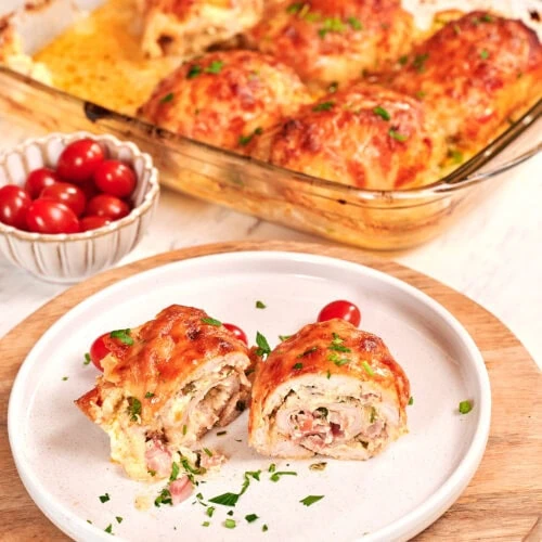 Famous Chicken Breast Rolls 2 Sliced chicken breast roll with creamy filling served on a plate with melted cheese and herbs