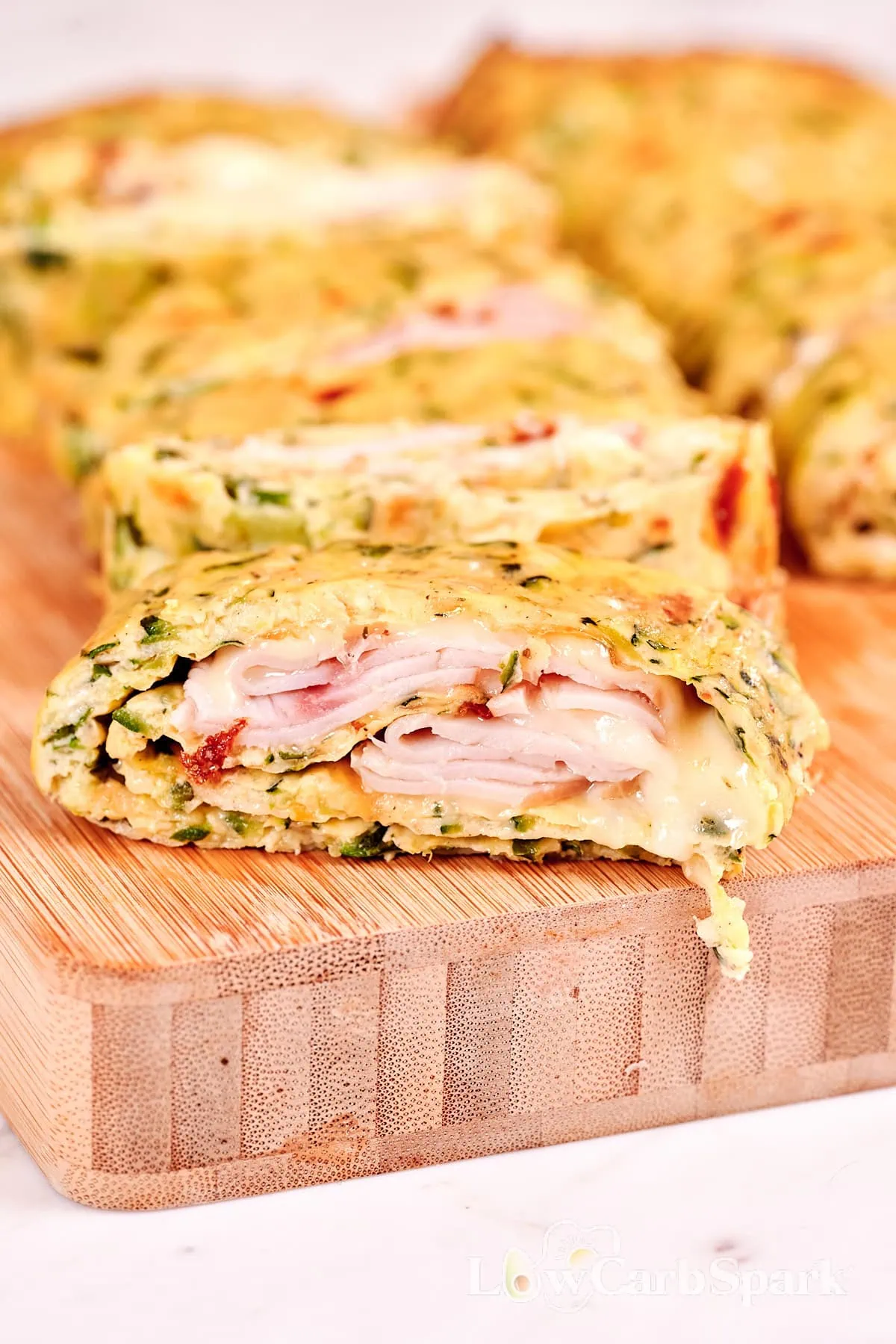 Zucchini Ham and Cheese Roll 13 Close-up of sliced zucchini ham and cheese roll filled with melted cheese and deli ham.