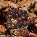 Fudgy pistachio brownies with a green pistachio butter swirl and chopped pistachios on top.