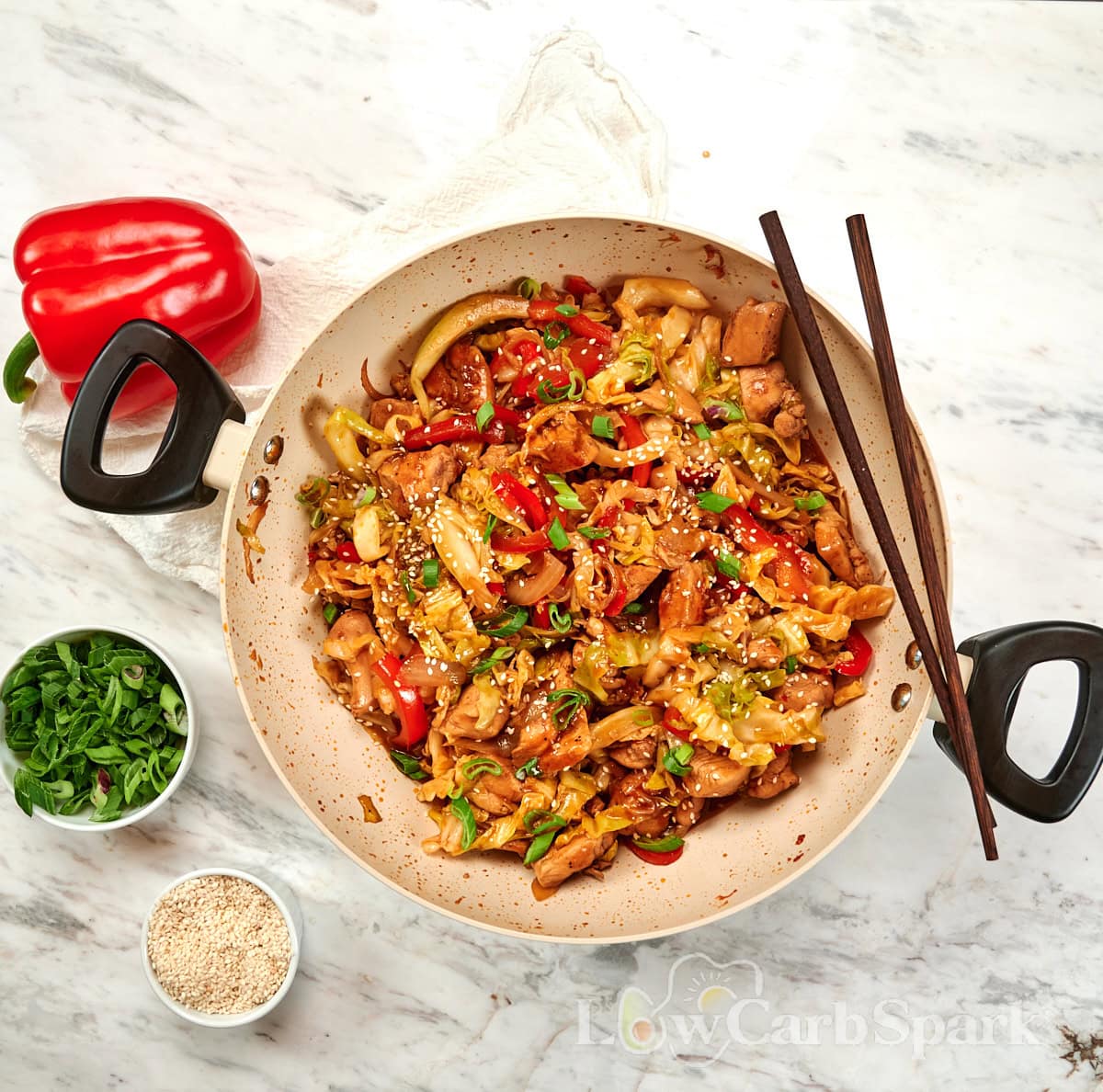 Chicken and Cabbage Stir Fry 12 Large skillet filled with high-protein chicken and cabbage stir fry topped with sesame seeds and sliced green onions.