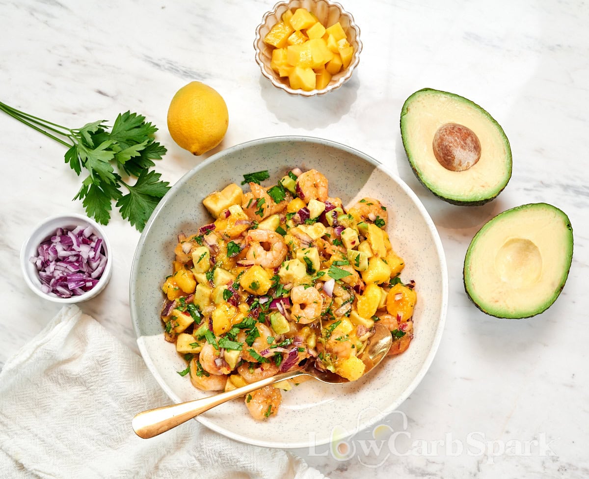 High-Protein Shrimp Mango Avocado Salad 3 Overhead view of high-protein shrimp mango avocado salad made with shrimp, mango, avocado, red onion, parsley, and lemon dressing.