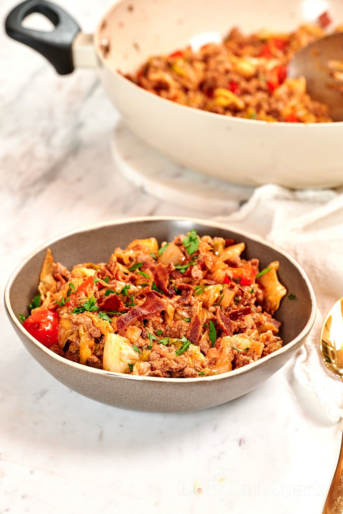 One-Pan Cajun Beef and Cabbage Skillet 2 Bowl of one-pan Cajun beef and cabbage skillet topped with crispy bacon and fresh parsley.