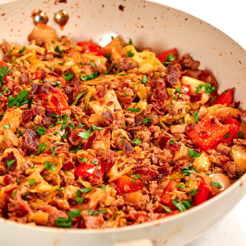One-Pan Cajun Beef and Cabbage Skillet 16 Close-up of Cajun beef and cabbage skillet with seasoned ground beef, tender cabbage, bacon, and red bell peppers cooked in one pan.