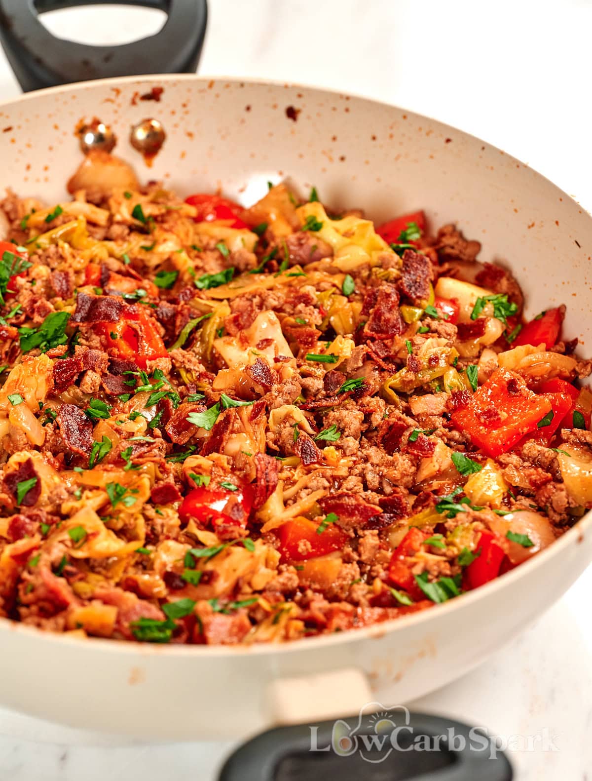 One-Pan Cajun Beef and Cabbage Skillet 15 Close-up of Cajun beef and cabbage skillet with seasoned ground beef, tender cabbage, bacon, and red bell peppers cooked in one pan.