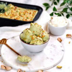 Creamy pistachio cottage cheese ice cream topped with chopped pistachios and served in a bowl, an easy high protein frozen dessert.