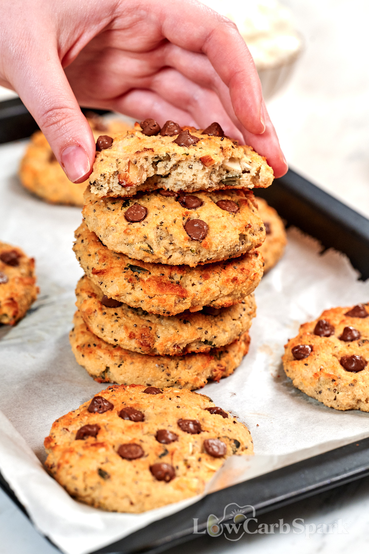 High-Protein Cottage Cheese Breakfast Cookies 3 Soft and chewy High-Protein Cottage Cheese Breakfast Cookies stacked on a baking tray, with one cookie broken in half to show the fluffy, protein-packed interior and chocolate chips.