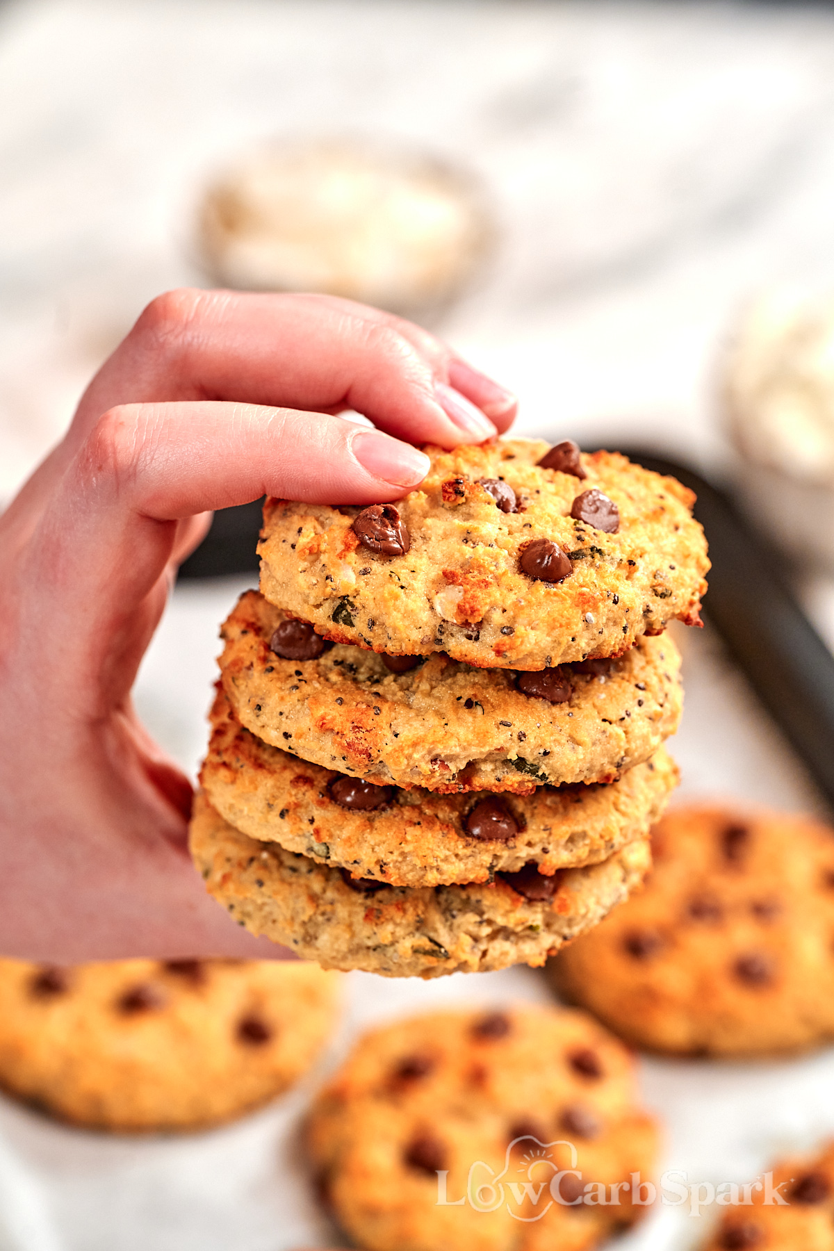 High-Protein Cottage Cheese Breakfast Cookies 1 Hand holding a stack of High-Protein Cottage Cheese Breakfast Cookies loaded with chocolate chips, made with cottage cheese and wholesome ingredients for an easy high-protein breakfast or snack.