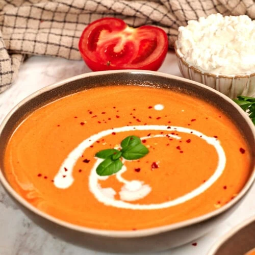 High-Protein Tomato Soup with Cottage Cheese 12 Creamy high-protein tomato soup made with roasted tomatoes and cottage cheese, topped with a swirl of cream, fresh basil, and red pepper flakes.