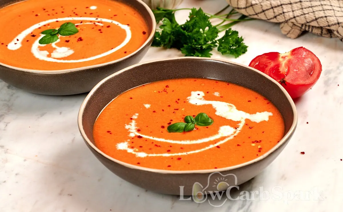 High-Protein Tomato Soup with Cottage Cheese 10 Two bowls of creamy roasted tomato soup with cottage cheese, garnished with fresh basil, cream, and red pepper flakes for an easy high-protein meal.
