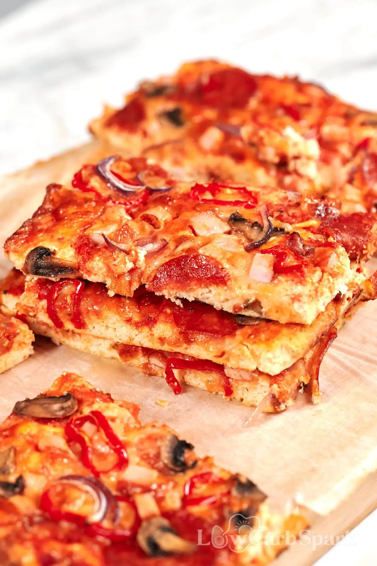 Sheet Pan Cottage Cheese Pizza 8 Stacked slices of sheet pan cottage cheese pizza with a soft high-protein cottage cheese crust, pizza sauce, pepperoni, mushrooms, and onions.